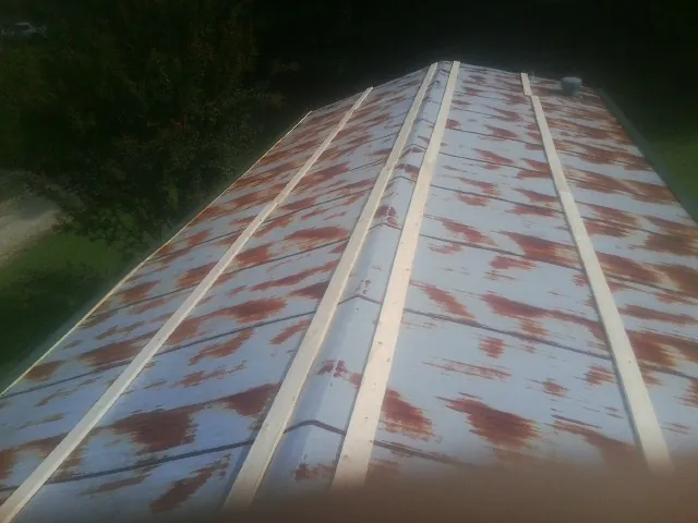 Rusted metal roof panels with new wood purlins before replacement — Storm Damage Roof Repair in Morehead by Roofing Brothers